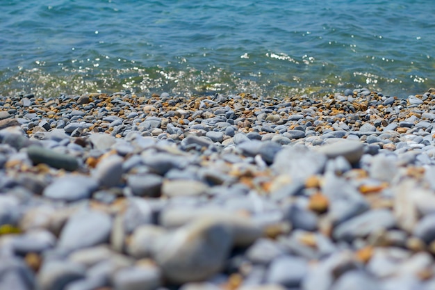 Pebble sea shore Praia de seixos e água do mar azul-turquesa