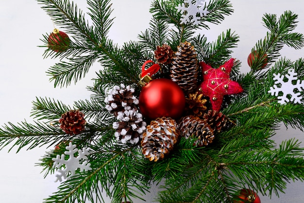 Peça central da mesa de Natal com pinhas decoradas douradas e flocos de neve