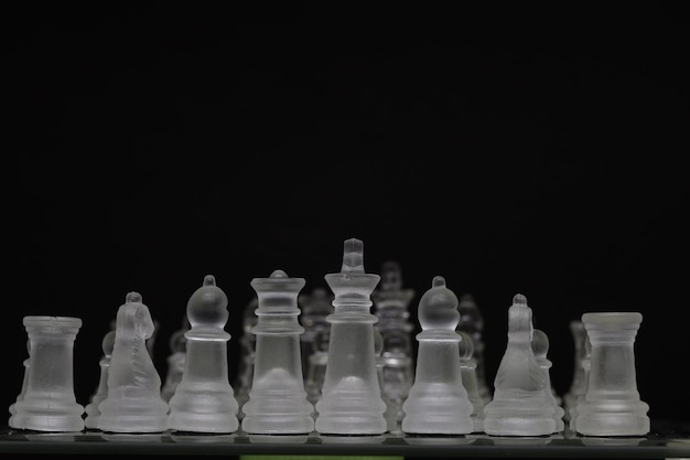 Peça de xadrez translúcida confronta com peça de xadrez transparente com fundo escuro