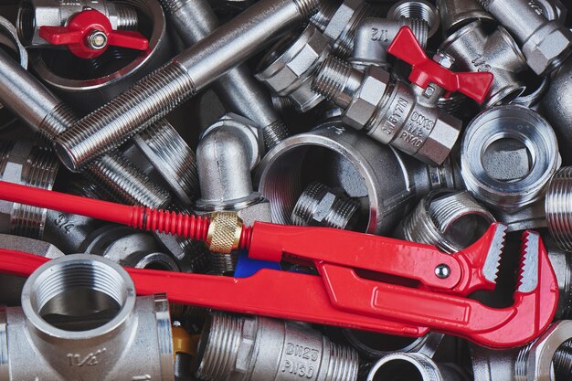 Peças de canalização e ferramentas de metal. Chave de gás e torneiras vermelhas. Close-up, vista superior.