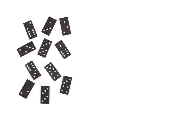 Peças de dominó pretas sobre um fundo branco com espaço de cópia em uma vista superior