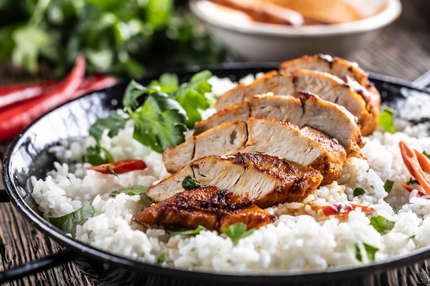 Pecho de pollo a la parrilla servido en una sartén con arroz de jazmín y chiles