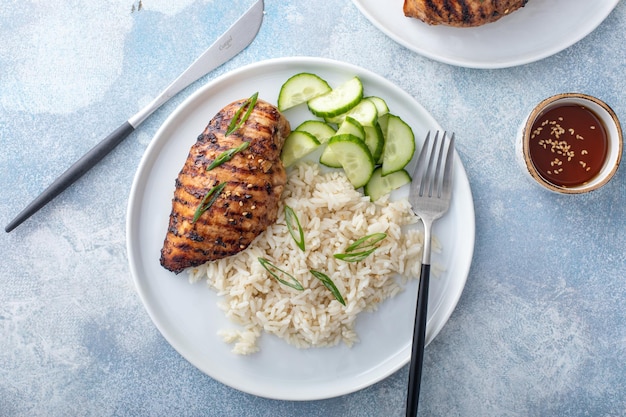 Foto pecho de pollo teriyaki a la parrilla con arroz y pepino fresco