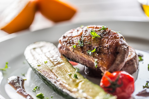 Pechuga de pato asada con calabacín, tomate y perejil.