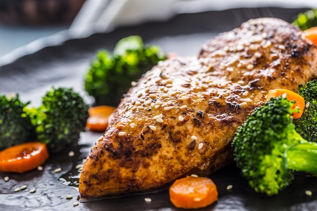 Pechuga de pollo asada con brócoli, zanahoria y sésamo.