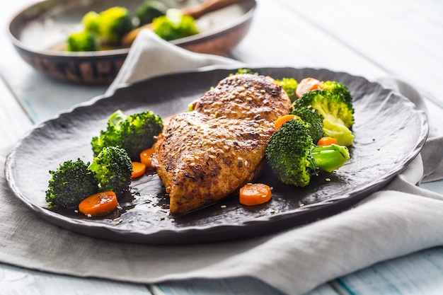 Pechuga de pollo asada con brócoli, zanahoria y sésamo.