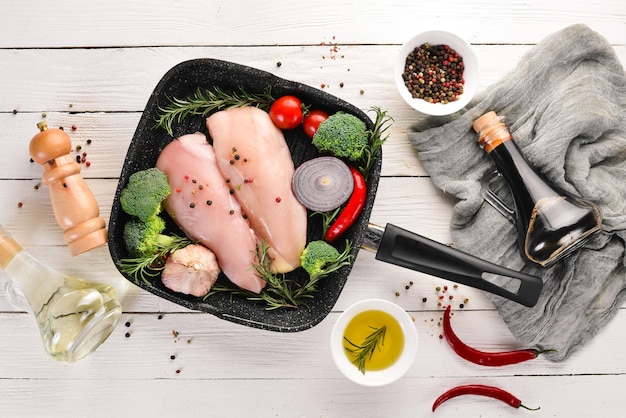 Pechuga de pollo cruda con especias y hierbas Barbacoa Sobre un fondo de madera blanca Vista superior Espacio de copia libre