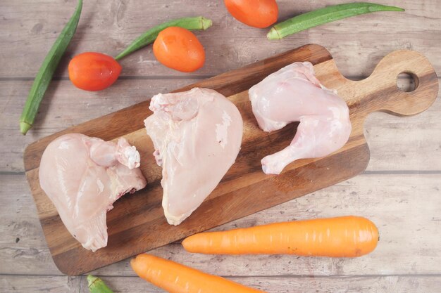 Pechuga de pollo cruda en una tabla de cortar