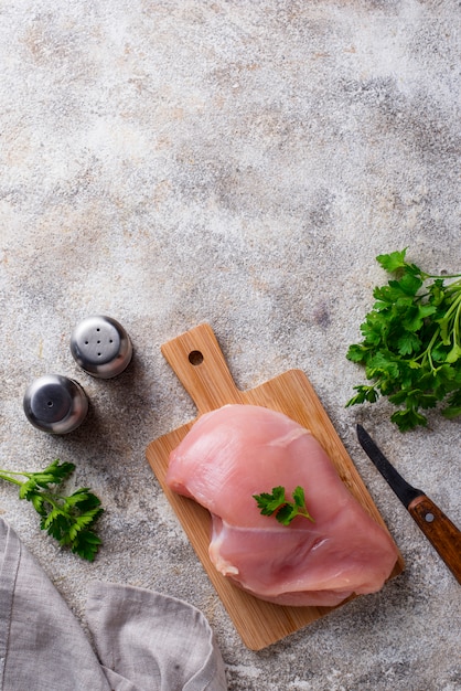 Pechuga de pollo cruda en tabla de cortar