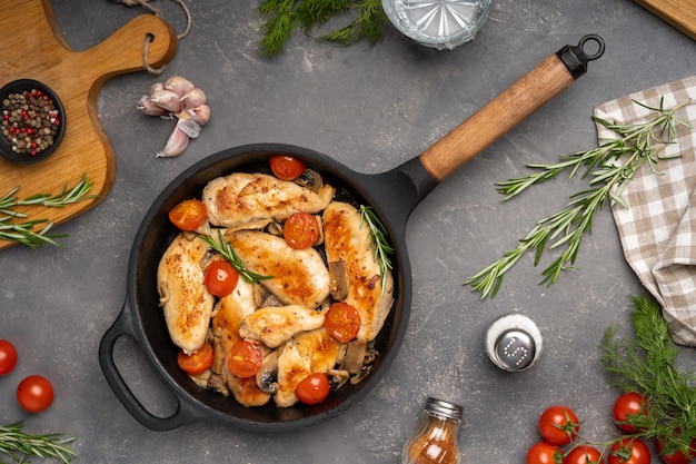 Pechuga de pollo a la parrilla o filete con tomate en sartén de hierro vista superior foto de alta calidad