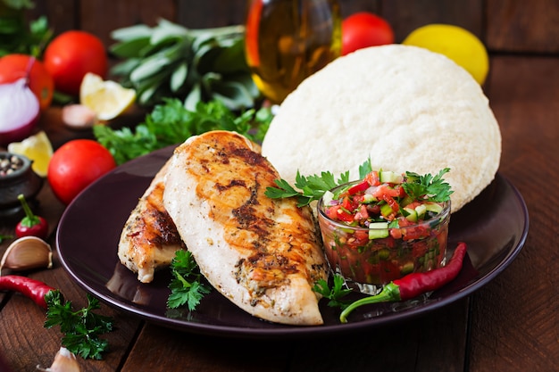 Pechuga de pollo a la parrilla con salsa de tomate fresco y pita.