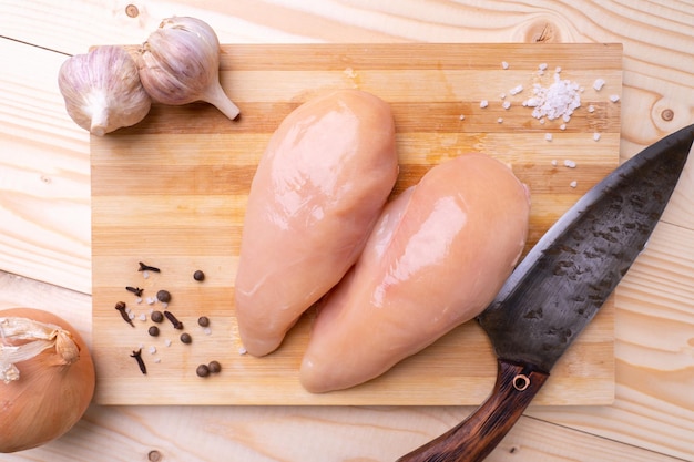 Pechuga de pollo sin piel sobre una tabla de cortar, vista superior