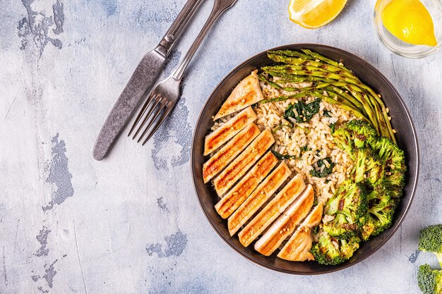 Pechuga de pollo a la plancha con arroz integral espinacas brócoli espárragos concepto de dieta alimentación saludable