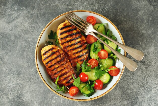 Pechuga de pollo a la plancha con ensalada de tomates cherry, pepinos, rúcula y perejil