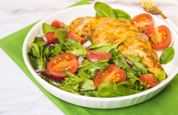 Foto pechuga de pollo a la plancha con ensalada verde de ensalada de verduras frescas