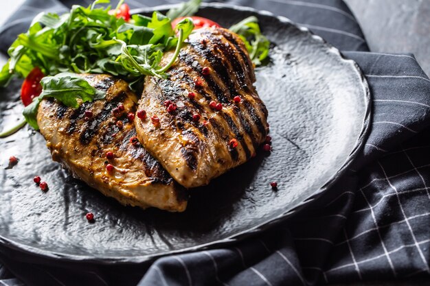 Pechuga de pollo a la plancha con especias, pimienta, tomates y rúcula.