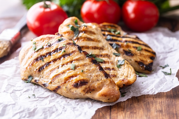 Pechuga de pollo a la plancha sobre tablero de carnicero de cerca.