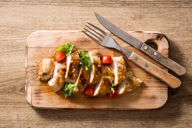 Pechuga de pollo a la plancha con verduras en la mesa de madera