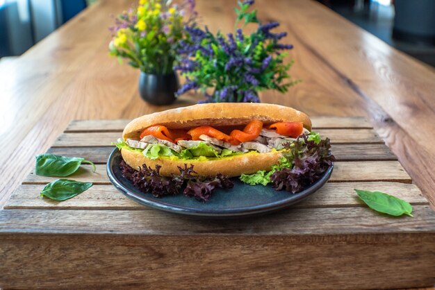 Pechuga de pollo salmón ahumado en sándwich de pan de centeno sobre mesa de madera