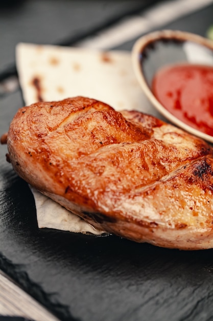 Pechugas de pollo sanas a la parrilla marinadas cocinadas en una barbacoa de verano