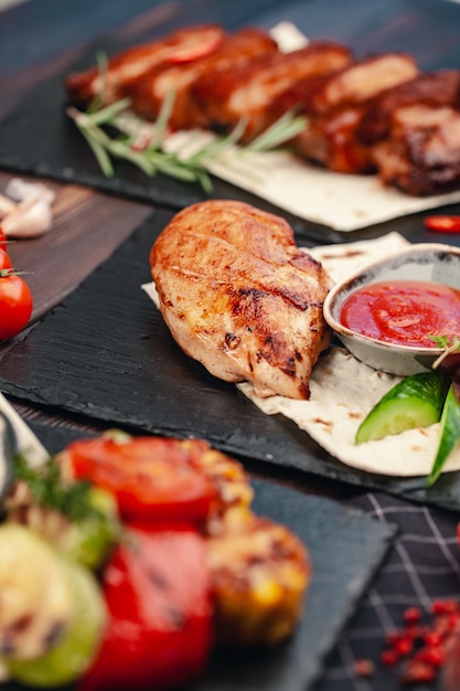 Pechugas de pollo sanas a la parrilla marinadas cocinadas en una barbacoa de verano