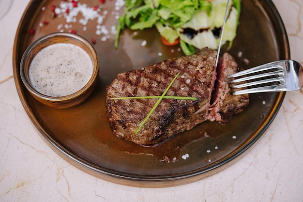 Pedaço de bife cortado com garfo e faca