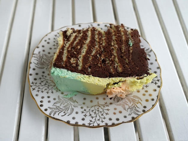 Pedaço de bolo com creme colorido por cima no prato