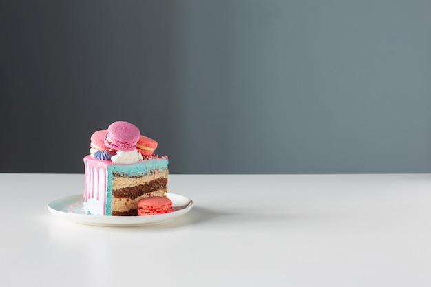 pedaço de bolo com decoração rosa e azul na mesa branca