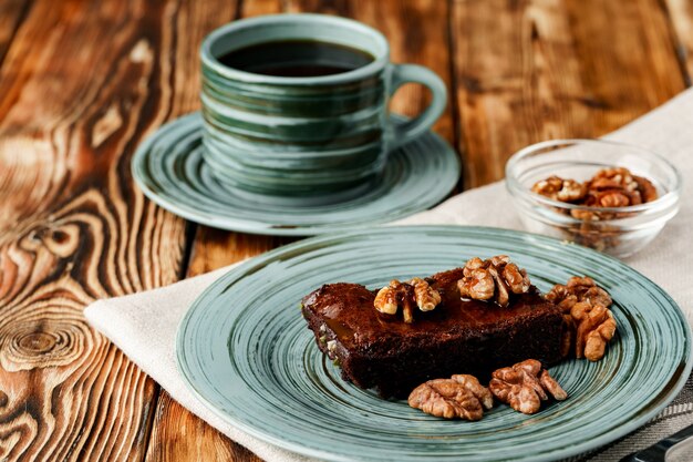 Pedaço de bolo de chocolate com nozes no prato verde