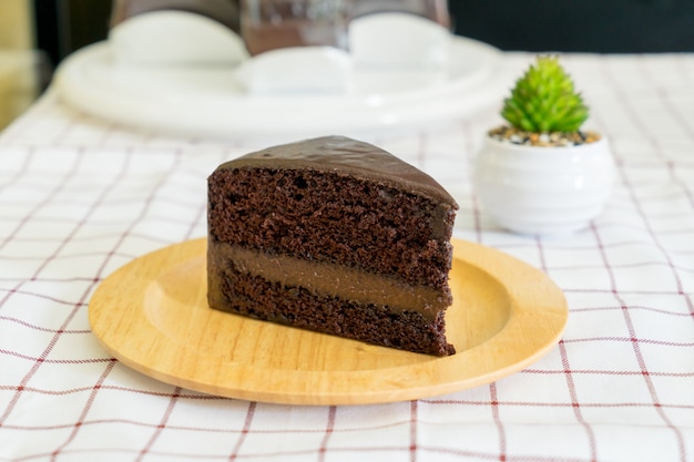 Pedaço de bolo de chocolate delicioso na placa de madeira