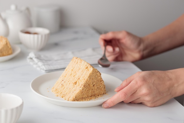 Pedaço de bolo de mel caseiro em camadas na mesa branca