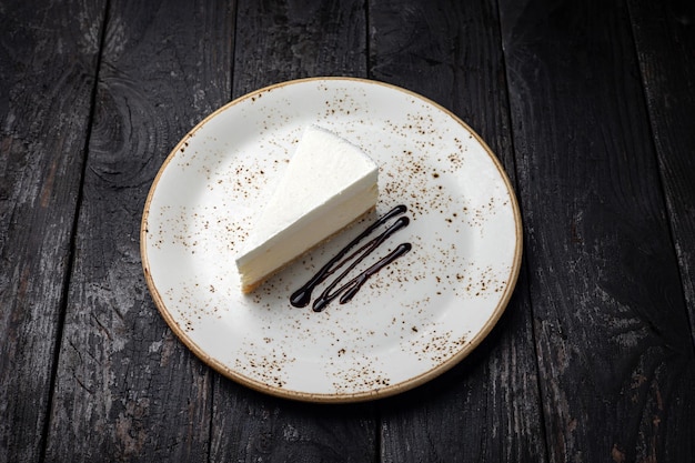 pedaço de bolo de queijo com creme e chocolate em um prato branco