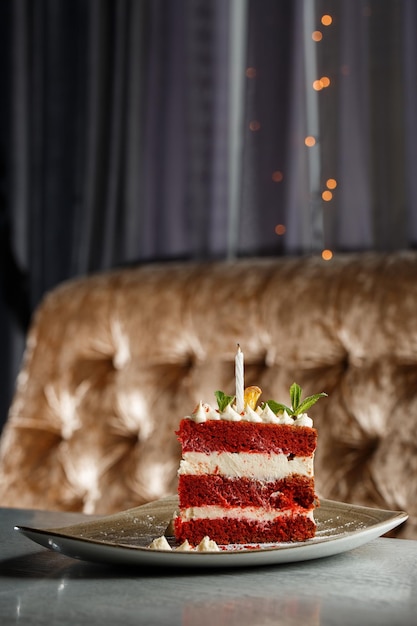 Pedaço de bolo de veludo vermelho com textura perfeita em placa fosca na mesa cinza Fatia de delicioso bolo de veludo vermelho caseiro com framboesa e chocolate
