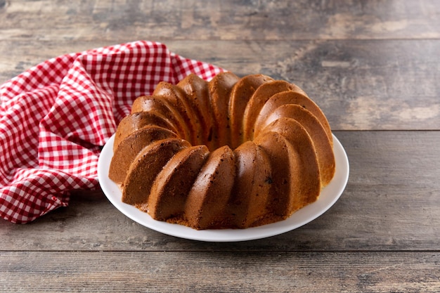 Pedaço de bolo tradicional com passas na mesa de madeira