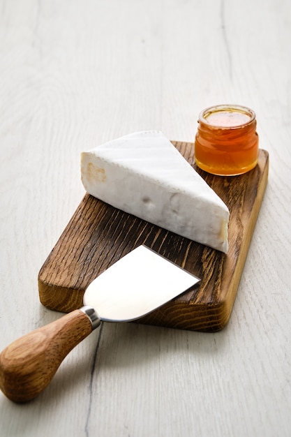 Pedaço de brie macio ou queijo camembert na tábua de cortar