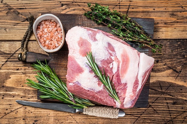 Pedaço de carne crua de pescoço de porco na tábua de madeira. de madeira