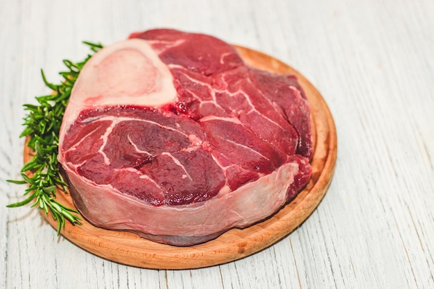 Pedaço de carne fresca bife grande no ossobuco com raminho de alecrim