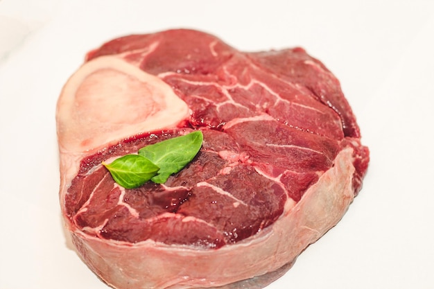 Pedaço de carne fresca bife grande no ossobuco com raminho de alecrim