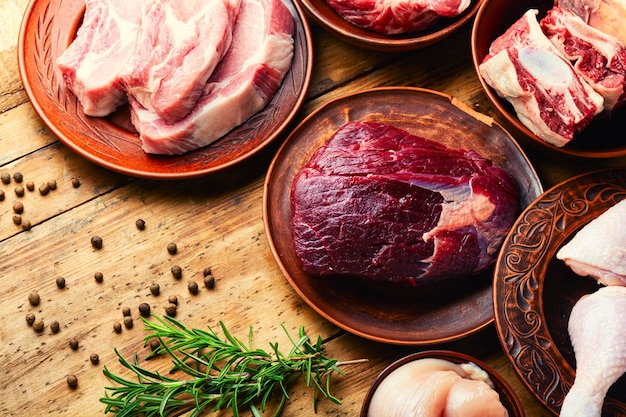 Pedaço de carne fresco na mesa da cozinha. feal, porco e frango para cozinhar.