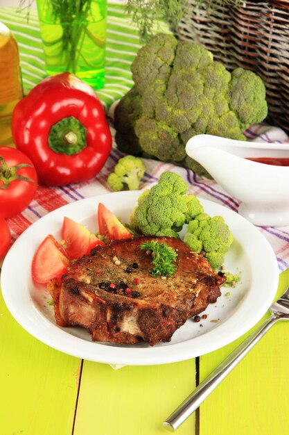 Pedaço de carne frita no prato na mesa de madeira closeup