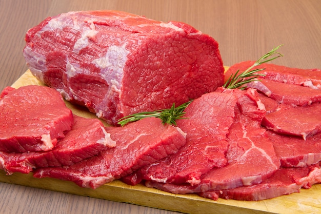 Pedaço de carne vermelha enorme e bife na mesa de madeira