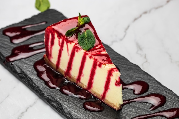 Pedaço de cheesecake com geléia de morangos frescos e hortelã Cheesecake caseiro saboroso