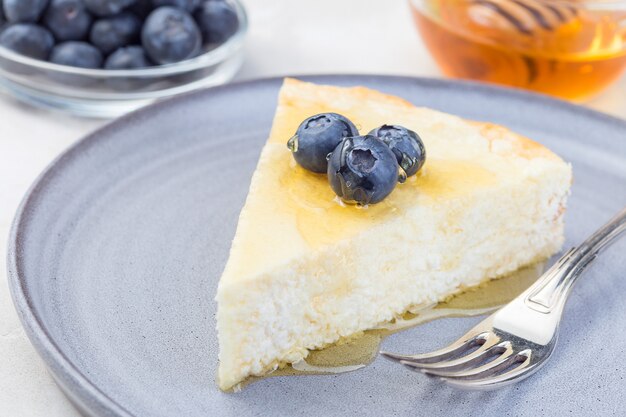 Pedaço de cheesecake com mirtilo e mel