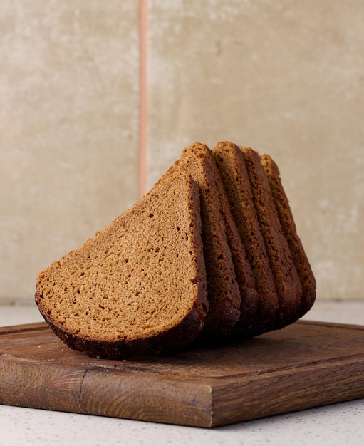 Pedaço de pão de centeio triangular em uma tábua de madeira