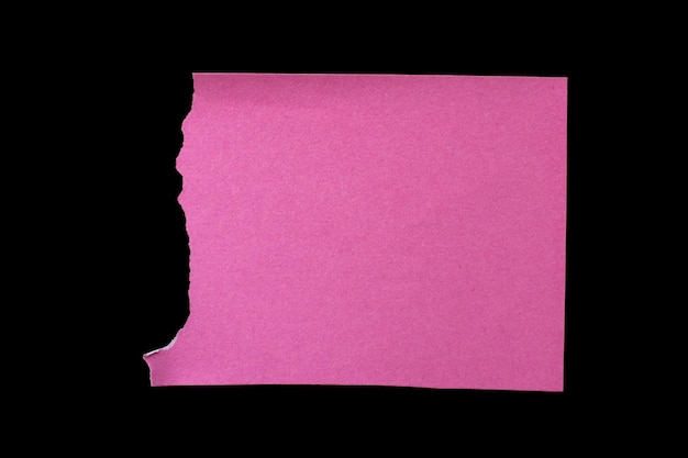 Pedaço de papel rasgado rosa isolado em fundo preto com espaço de cópia para texto