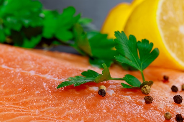 Pedaço de salmão cru com ingredientes em mármore na mesa