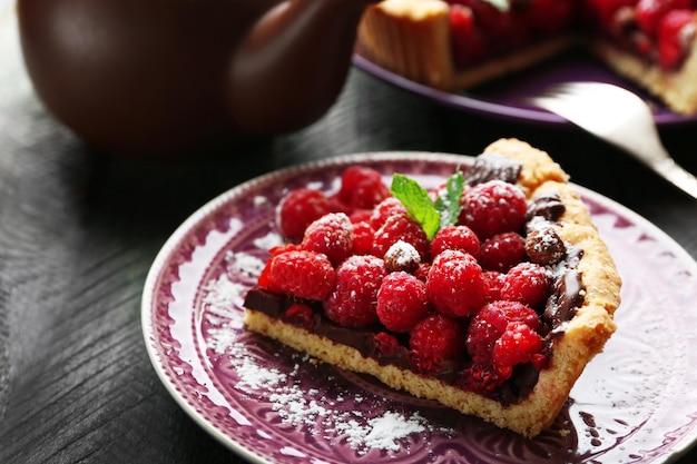 Pedaço de torta com framboesas frescas em fundo de madeira