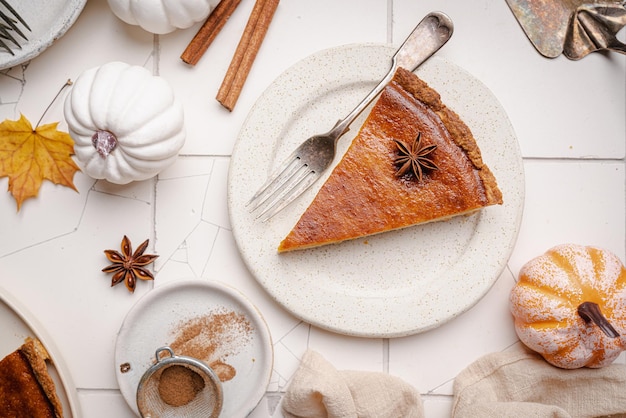 Pedaço de torta de abóbora americana com canela na vista superior de fundo de azulejo branco