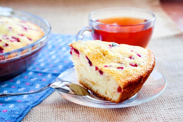 Pedaço de torta de Acerola na placa de vidro e xícara de chá