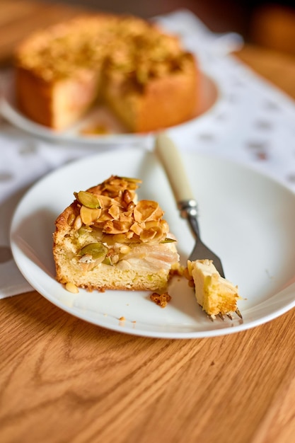 Pedaço de torta de torta de maçã ou pêra com nozes de caramelo na vista superior do espaço de cópia de mesa de madeira